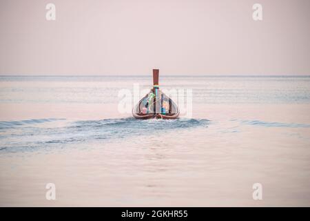 Bateau à longue queue naviguant dans une mer calme aux premières heures du matin Banque D'Images