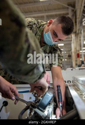 210426-N-UD000-1039 PORTSMOUTH, Virginie (26 avril 2021) le technicien en équipement de soutien à l'aviation, Airman Stephen D. Smith, de Parme, Ohio, affecté au porte-avions USS George H. W. Bush (CVN 77), travaille sur une pièce de machinerie. GHWB est actuellement dans le chantier naval de Norfolk pour sa disponibilité incrémentale prévue d'amarrage. Banque D'Images