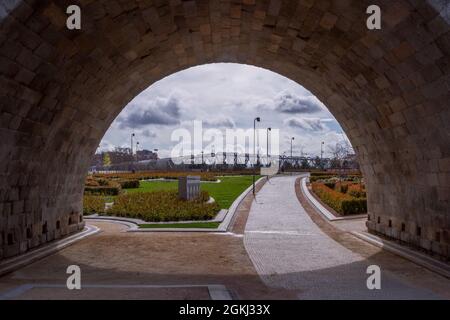 Vue sur le parc de la rivière Madrid avec une passerelle en métal en arrière-plan depuis une arche du pont de Tolède Banque D'Images