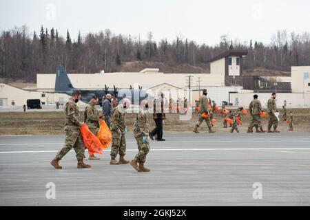 Des aviateurs de service actif affectés à la 3e Escadre, des aviateurs de réserve du 477e groupe de chasseurs et des gardes nationaux de l'Alaska Air de la 176e Escadre, effectuent une marche sur les débris d'objets étrangers sur la ligne aérienne à la base interarmées Elmendorf-Richardson (Alaska), le 29 avril 2021. Les aviateurs de la JBER ont effectué la marche du FOD pour éliminer les débris qui pourraient endommager l'avion et entraver la préparation de la mission. Banque D'Images