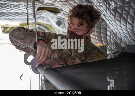 Sergent de l'armée Kevin Swanson, ingénieur de vol de la Compagnie B, 2e Bataillon de l'aviation générale de soutien, 501e Régiment de l'aviation, Brigade de l'aviation de combat, 1re Division blindée de fort Bliss, Texas, montre des soldats de la 738e compagnie médicale de soutien de zone, 81e Commandement de la troupe, Garde nationale de Lafayette de l'Indiana, Ind., Comment apposer une litière dans un avion CH-47 Chinook, pendant l'exercice Guardian Response 21 à Camp Atterbury, Ind., le 29 avril 2021. L'intervention du tuteur est un exercice d'intervention d'urgence en territoire intérieur à plusieurs composantes dirigé par la 78e Division d'entraînement de la Réserve de l'Armée de terre. Banque D'Images