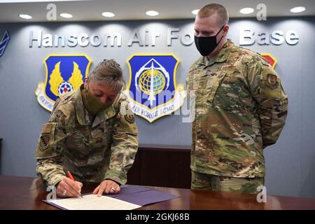 Le colonel Katrina Stephens, commandant de l'installation, signe une proclamation en reconnaissance de la Journée nationale de l'Arbor à la base aérienne de Hanscom, au Massachusetts, le 29 avril, alors que le Chef de commandement, Sgt. William Hebb regarde. Arbor Day est une célébration annuelle qui favorise la plantation d'arbres et les soins. Banque D'Images