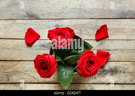 Belles roses visibles à travers le trou sur fond en bois Banque D'Images