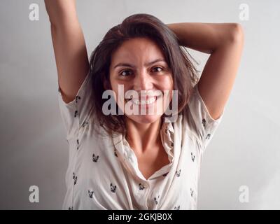 Jeune Beauté cheveux brun femme péruvienne semble heureuse avec ses bras vers le haut dans l'air Banque D'Images