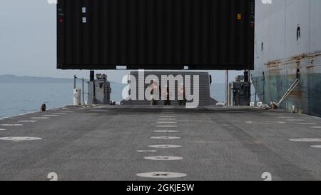 L’équipage du pont-jetée du système d’éclairage de la Marine (INLS) amélioré de la Marine se prépare à sécuriser un conteneur d’entreposage abaissé de l’USNS Bob Hope (T-AKR-300) lors de l’exercice multinational Defender Europe 21 (DE21) de l’OTAN. DE21 est conçu pour accroître l'interopérabilité entre les pays partenaires de la mer Adriatique. Banque D'Images