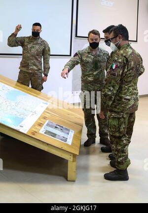 Un parachutiste de l'armée américaine et un officier de la Bourse britannique affectés à la 82e Division aéroportée plans d'étude avec des membres du service de l'armée italienne affectés à la Brigade aéroportée de Folgore pendant l'opération multinationale aéroportée Swift Response à la base aérienne de Mihail Kogalniceanu, Roumanie, le 3 mai 2021. SWIFT Response 21 est le premier exercice de l'opération plus vaste Defender Europe 21 au cours de laquelle les forces américaines travaillent en étroite collaboration avec les alliés et les partenaires de l'OTAN. Banque D'Images