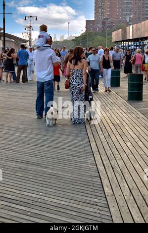 Une famille marchant le long d'un trottoir en bois à Brighton Beach, Brooklyn, New York, États-Unis Banque D'Images