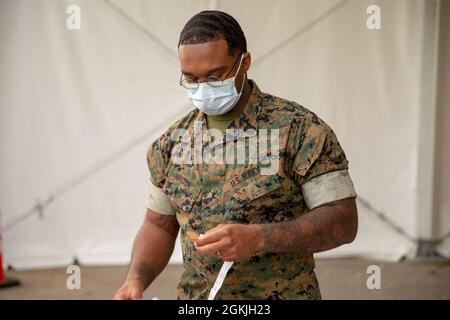 L'officier de la marine américaine de 3e classe John Walton, affecté à la division marine 2d, Camp Lejeune, Caroline du Nord, prépare son poste de travail au Centre de vaccination communautaire du Pipkin Building, au Liberty Bowl Memorial Stadium, à Memphis, Tennessee, le 3 mai 2021. Le Commandement du Nord des États-Unis, par l'intermédiaire de l'Armée du Nord des États-Unis, demeure déterminé à fournir un soutien continu et souple du ministère de la Défense à l'Agence fédérale de gestion des urgences dans le cadre de la réponse pangouvernementale à la COVID-19. Banque D'Images