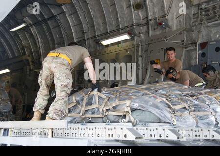 Les parachutistes et les aviateurs préparent et chargent du matériel pour le transport international à l'appui de l'exercice Swift Response 2021, le 4 mai 2021, à Green Ramp, sur fort Bragg, Caroline du Nord. Les palettes d'équipement sont équipées de parachutes pour les gouttes d'air en Estonie, livrées avant l'attaque aérienne par entrée forcée conjointe. Banque D'Images