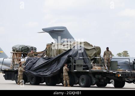 Les parachutistes et les aviateurs préparent et chargent du matériel pour le transport international à l'appui de l'exercice Swift Response 2021, le 4 mai 2021, à Green Ramp, sur fort Bragg, Caroline du Nord. Les palettes d'équipement sont équipées de parachutes pour les gouttes d'air en Estonie, livrées avant l'attaque aérienne par entrée forcée conjointe. Banque D'Images