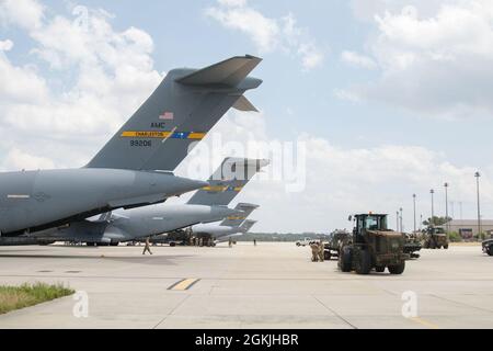 Les parachutistes et les aviateurs préparent et chargent du matériel pour le transport international à l'appui de l'exercice Swift Response 2021, le 4 mai 2021, à Green Ramp, sur fort Bragg, Caroline du Nord. Les palettes d'équipement sont équipées de parachutes pour les gouttes d'air en Estonie, livrées avant l'attaque aérienne par entrée forcée conjointe. Banque D'Images