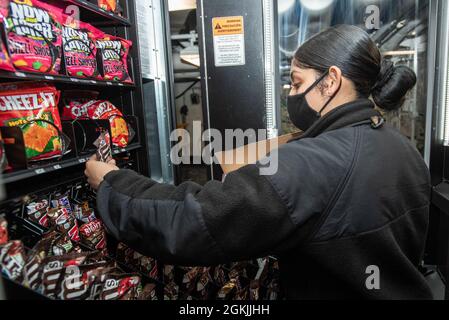 210504-N-WU964-1088 YOKOSUKA (Japon), le 4 mai 2021, le spécialiste de la vente au détail Seaman Helaina Olvera, de Mission (Texas), réapprovisionnera un distributeur automatique sur le seul porte-avions déployé par l'avant de la marine américaine USS Ronald Reagan (CVN 76). Ronald Reagan, le navire amiral du Carrier Strike Group 5, fournit une force prête au combat qui protège et défend les États-Unis, ainsi que les intérêts maritimes collectifs de ses alliés et partenaires dans la région Indo-Pacifique. Banque D'Images