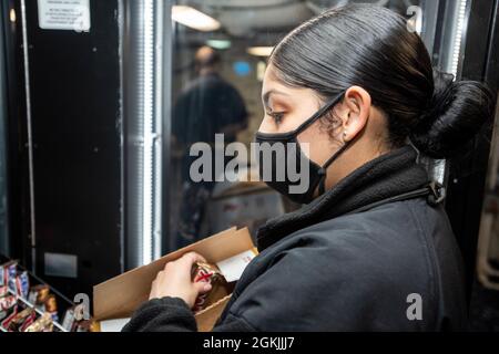 210504-N-WU964-1086 YOKOSUKA (Japon), le 4 mai 2021, le spécialiste de la vente au détail Seaman Helaina Olvera, de Mission (Texas), réapprovisionnera un distributeur automatique sur le seul porte-avions déployé par l'avant de la marine américaine USS Ronald Reagan (CVN 76). Ronald Reagan, le navire amiral du Carrier Strike Group 5, fournit une force prête au combat qui protège et défend les États-Unis, ainsi que les intérêts maritimes collectifs de ses alliés et partenaires dans la région Indo-Pacifique. Banque D'Images