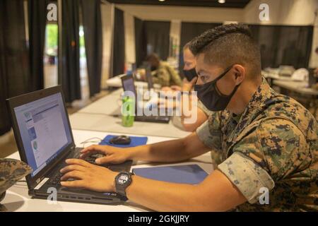 Caporal de lance du corps des Marines des États-Unis Daniel Olguin, affecté à la 2d Marine Division, Camp Lejeune (Caroline du Nord), saisit des données au Community Vaccine Centre du Pipkin Building, au Liberty Bowl Memorial Stadium, à Memphis, Tennessee, le 4 mai 2021. Le Commandement du Nord des États-Unis, par l'intermédiaire de l'Armée du Nord des États-Unis, demeure déterminé à fournir un soutien souple et continu du ministère de la Défense à l'Agence fédérale de gestion des urgences dans le cadre de la réponse pangouvernementale à la COVID-19. Banque D'Images