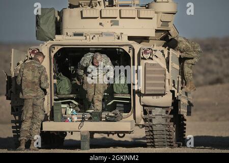 Garde nationale de l'armée de l'Idaho 2Lt. Victoria Schuler (au centre) et l'équipage se préparent à l'exercice de qualification des armes à feu de la gamme 10. La Compagnie Charlie de la 116e équipe de combat de la Brigade de Cavalry a commencé l'entraînement annuel le matin du 1er mai 2021. Les hommes et les femmes de C Company ont suivi une formation annuelle réussie et stimulante au sein de l'OCTC. L'unité a rempli la Table VI de Bradley Gunnery, qualifiant 11 équipages de Bradley. Les escadrons d'infanterie de démontage ont terminé leurs qualifications pour les six escadrons. L'exercice de formation sur le terrain comportait des défis situationnels pour récupérer les véhicules en descente Banque D'Images