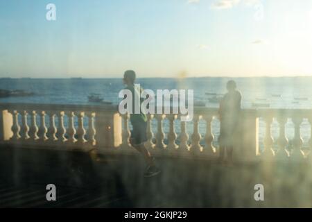 Salvador, Bahia, Brésil - 17 juin 2021 ; balustrade de la plage de Porto da Barra vue à travers le verre sale de l'arrêt de bus. Banque D'Images