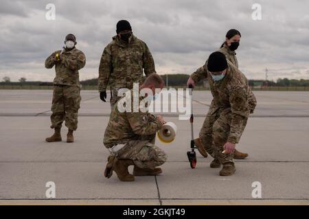 Des aviateurs de la US Air Force affectés au 435e Escadron d'intervention en cas d'urgence marquent des places de stationnement pour un C-17 Globemaster III lors de l'exercice Swift Response 21 à la base aérienne de Pápa, en Hongrie, le 6 mai 2021. L'exercice a mis en évidence des initiatives d'emploi de combat agile par le biais d'une formation conjointe et combinée dans un environnement simulé contesté. Banque D'Images