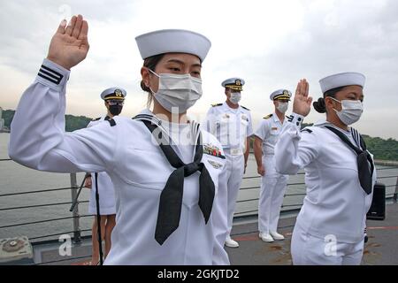 YOKOSUKA, Japon (7 mai 2021) — Spécialiste des services de détail 3e classe Fangfang Wen, originaire de Chine, à gauche, et Spécialiste des services de détail 3e classe Chloe Nichole Luz Rodriguez, originaire des Philippines, à droite, récite l'Oath of Allegiance à bord de l'USS Mustin (DDG 89) lors d'une cérémonie de naturalisation des services de citoyenneté et d'immigration aux États-Unis. L'événement a été la première cérémonie de naturalisation tenue à bord d'un navire actif de la Marine américaine pendant la pandémie COVID-19. Mustin est déployé au Japon et est stationné au Commandant Fleet Activities Yokosuka (CFAY) dans le cadre de la 7e FL des Etats-Unis Banque D'Images