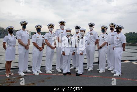 YOKOSUKA, Japon (7 mai 2021) — Spécialiste des services de détail 3e classe Chloe Nichole Luz Rodriguez, originaire des Philippines, au centre à gauche, et Spécialiste des services de détail 3e classe Fangfang Wen, originaire de Chine, au centre à droite, pose comme nouveaux citoyens américains avec des officiers de l'USS Mustin (DDG 89) lors d'une cérémonie de naturalisation des services de citoyenneté et d'immigration des États-Unis. L'événement a été la première cérémonie de naturalisation tenue à bord d'un navire actif de la Marine américaine pendant la pandémie COVID-19. Mustin est déployé à l'avant au Japon et est en poste au commandant des activités de la flotte de Yokosuka (CFAY) en tant que partie Banque D'Images