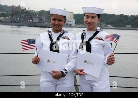 YOKOSUKA, Japon (7 mai 2021) — Spécialiste des services au détail 3e classe Chloe Nichole Luz Rodriguez, à gauche, originaire des Philippines et Spécialiste des services au détail 3e classe Fangfang Wen, à droite, originaire de Chine, pose comme nouveaux citoyens américains après une cérémonie de naturalisation des services de citoyenneté et d'immigration des États-Unis. L'événement a été la première cérémonie de naturalisation tenue à bord d'un navire actif de la Marine américaine pendant la pandémie COVID-19. Mustin est déployé au Japon et est stationné au commandant des activités de la flotte Yokosuka (CFAY) dans le cadre de la 7e flotte des États-Unis. Depuis plus de 75 ans, CFAY Banque D'Images