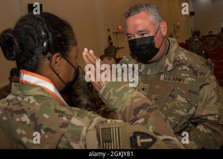 Sergent de l'armée américaine 1re classe Nicole Perkins, un soldat de signal de la 36e Division d'infanterie, Task Force Spartan, salue Brig. Le général Jonathan C. Moyer, 335e théâtre de signalisation commandant provisoire, après avoir placé la médaille de bronze de l'ordre de Mercure autour de son cou, le 8 mai 2021, sur le Camp Arifjan, Koweït. Perkins a été l'un des 25 soldats signal qui ont reçu l'honneur devant ses pairs et le personnel de commandement de TF Spartan lors d'une petite cérémonie. Banque D'Images