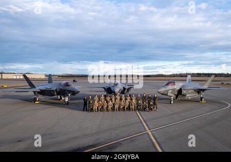 Le marin américain, les aviateurs et les responsables de la Marine posent pour une photo devant un F-35C de la Marine américaine, un F-35A de la Force aérienne américaine et un F-35B Lightning II du corps maritime américain sur la ligne de vol de la base aérienne d'Eielson, en Alaska, à l'appui de Northern Edge 2021, le 7 mai 2021. Environ 15,000 membres du service américain participent à un exercice de formation conjoint organisé par les forces aériennes du Pacifique des États-Unis du 3 au 14 mai 2021, à l'intérieur et au-dessus du complexe de la portée interarmées du Pacifique Alaska, du golfe de l'Alaska et de la zone d'activités maritimes temporaires. Banque D'Images