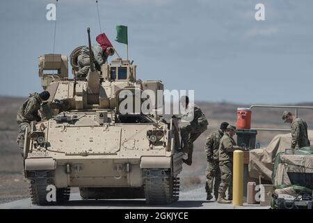 Garde nationale de l'armée de l'Idaho 2Lt. Victoria Schuler et l'équipage retournent au point de munitions pour décharger l'équipement et changer d'équipe. La Compagnie Charlie de la 116e équipe de combat de la Brigade de Cavalry a commencé l'entraînement annuel le matin du 1er mai 2021. Les hommes et les femmes de C Company ont suivi une formation annuelle réussie et stimulante au sein de l'OCTC. L'unité a rempli la Table VI de Bradley Gunnery, qualifiant 11 équipages de Bradley. Les escadrons d'infanterie de démontage ont terminé leurs qualifications pour les six escadrons. L'exercice de formation sur le terrain comprenait des défis situationnels pour récupérer les véhicules en aval ainsi que Banque D'Images