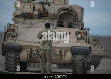 Un soldat de Charlie Company dirige un véhicule de combat Bradley en position pour le ravitaillement. Charlie Company de la 116e équipe de combat de la Brigade de Cavalry a commencé l'entraînement annuel le matin du 1er mai 2021 et est revenu du Centre d'entraînement au combat d'Orchard le soir du 13 mai. Les hommes et les femmes de C Company ont suivi une formation annuelle réussie et stimulante au sein de l'OCTC. L'unité a rempli la Table VI de Bradley Gunnery, qualifiant 11 équipages de Bradley. Les escadrons d'infanterie de démontage ont terminé leurs qualifications pour les six escadrons. L'exercice d'entraînement sur le terrain comprenait situatio Banque D'Images