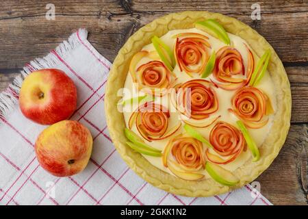 Roses aux pommes rouges et crème dans la tarte à la croûte. Banque D'Images