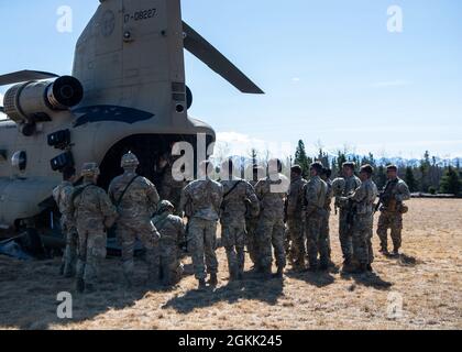 Un chef d'équipage CH-47 Chinook de l'armée américaine affecté à la Compagnie B, 1er Bataillon, 52e Aviation Regiment, fait un briefing des parachutistes de l'armée américaine avec le 1er Bataillon, 501e Régiment d'infanterie de parachutisme, 4e équipe de combat d'infanterie (Airborne), 25e Division d'infanterie, sur les procédures d'évacuation dans un champ près de fort Wainwright, Alaska, Avant une opération d'insertion de repérage à l'appui de Northern Edge 2021, le 10 mai 2021. Environ 15,000 membres du service américain participent à un exercice de formation conjoint organisé par les forces aériennes du Pacifique des États-Unis du 3 au 14 mai 2021, à l'intérieur et au-dessus du complexe de la portée de l'Alaska du Pacifique interarmées, le Gu Banque D'Images