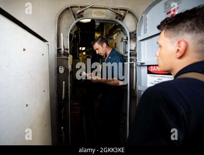 210511-N-RL695-1053 MER DES CARAÏBES - (11 mai 2021) -- le compagnon de Gunner's 2e Brandon Reznak, à gauche, et le compagnon de Gunner's 3e classe Cody Harris, affecté au navire de combat littoral USS Sioux City (LCS 11), variante Freedom, sécurisent les armes tandis que le navire prépare son entrée au port, le 11 mai 2021. Sioux City est déployée dans la zone d’opérations de la 4e flotte des États-Unis pour appuyer la mission de la Force opérationnelle interagences conjointe Sud, qui comprend des missions de lutte contre le trafic illicite de drogues dans les Caraïbes et le Pacifique oriental. Banque D'Images