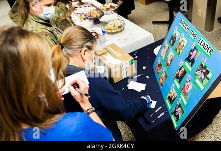 Les infirmières et les techniciens médicaux de la base aérienne Wright-Patterson, Ohio, Medical Center remplissent une feuille de papier avec leurs suppositions sur la photo d'enfance à laquelle appartient le membre de la 88e équipe de direction du Medical Group, lors d'un événement dans le cadre de la semaine d'appréciation des infirmières et techniciens médicaux, 12 mai 2021. Plusieurs événements ont eu lieu tout au long de la semaine pour témoigner de la reconnaissance des infirmières et des techniciens médicaux qui travaillent au centre médical Wright-Patterson. Banque D'Images