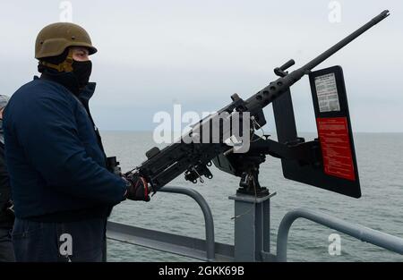 210512-N-PA358-1097 PORTSMOUTH, Virginie Machinist Mate 2nd Class Brandon Hampson, de Santa Cruz, Californie, est un mitrailleur de calibre .50 monté sur le plateau de vol du porte-avions de la classe Nimitz USS Harry S. Truman (CVN 75). L'USS Harry S. Truman (CVN 75) a quitté le chantier naval de Norfolk après avoir terminé une disponibilité supplémentaire de transporteur de 10 mois, prévue régulièrement, le navire a subi l'entretien, la réparation et l'inspection de divers équipements, y compris l'ingénierie, les systèmes de combat, le soutien d'aéronefs et la propulsion nucléaire. Banque D'Images