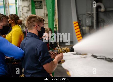 210513-N-EJ940-0038 OCÉAN ATLANTIQUE (13 mai 2021) Airman Joshua Noel, de Fountain, Colorado, décharge un dévidoir de flexible en mousse formant un film aqueux tandis que Airman Ben Schoenster, de East Hampton, New York, lit un manomètre dans la baie hangar du porte-avions de classe Nimitz USS Harry S. Truman (CVN 75) pendant les essais en mer après avoir complété une disponibilité incrémentielle de transporteur étendu. Les essais en mer comprennent un essai complet des systèmes et des technologies du navire afin de s’assurer que le navire est prêt à reprendre ses activités. Banque D'Images