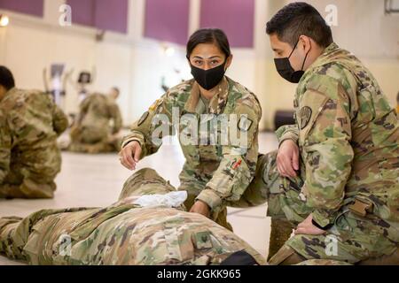 Sergent d'état-major de la Garde nationale de l'armée de New York. Azaneth Aquino, instructeur aa au 106e Institut régional de formation, montre comment envelopper un tourniquet « élevé et serré » aux étudiants dans une classe de combat Gareautrain au site de formation de Camp Smith le 13 mai 2021. Le cours de quatre jours prépare les soldats de n'importe quel MOS ou grade à fournir des soins médicaux de base sur le terrain à leur unité. Banque D'Images