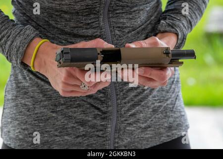 Coren Yastrzemsky, épouse du commandant Benelux de la garnison de l'armée américaine, assemble un pistolet M17 lors du défi conjoint, sur la base aérienne de Chièvres, Belgique, le 14 mai 2021. Cette journée d'événements militaires concurrentiels amicaux a eu lieu pour donner un aperçu de la vie des membres du service à leurs conjoints. Banque D'Images