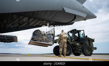 Des spécialistes du transport aérien affectés au 321e Escadron d’intervention en cas d’urgence déchargent du fret d’un C-17 Globemaster III de la Force aérienne des États-Unis affecté à la 437e Escadre de transport aérien au Centre d’entraînement de préparation au combat d’Alpena, au Michigan, le 16 mai 2021. Menée tous les deux ans, Mobility Guardian est le seul mécanisme officiel de niveau de service de la Force aérienne, Total Force, pour évaluer et valider les capacités dans les missions de mobilité mondiale rapide spécifiées et implicites dans la Stratégie de défense nationale de 2018. Banque D'Images