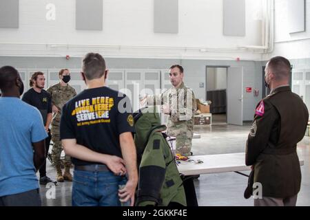 Sergent d'état-major de l'armée américaine Kevin Chancey, officier non commissionné de l'élimination des munitions explosives affecté à la 430e Ordnance Company (EOD), 60e commandant de la troupe, parle à un groupe de personnes au sujet des opérations d'élimination des munitions explosives lors d'une expérience de la Garde à l'arsenal de la Garde nationale à Benson, en Caroline du Nord, le 16 mai 2021. Environ 60 soldats du programme de soutien des recrues et leurs invités ont appris au sujet des systèmes d'armes individuels, des véhicules militaires à roues, des possibilités de carrière médicale au sein de la Garde nationale de l'Armée de Caroline du Nord et des opérations de la fin de journée. Le NCARNG est un Banque D'Images