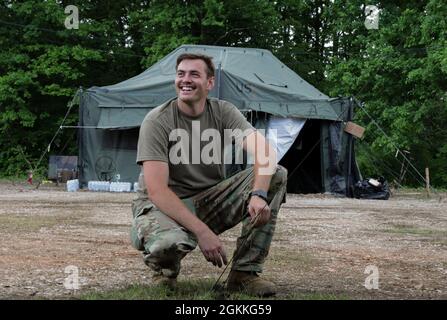 SPC. James Perdue, chef d'équipage de la compagnie Alpha de la Garde nationale de l'Armée de l'Alabama, 1-131 Assault Helicopter Battalion, sécurise une tente à un pieu au sol en utilisant 550 cordes pendant l'intervention immédiate dans le cadre de DEFENDER-Europe 21, près de l'aéroport international de Tuzla, Bosnie-Herzégovine, 17 mai 2021. Au cours de cet exercice, les troupes utilisent des tentes à usage général pour une protection supplémentaire contre les éléments. (Photos de la Garde nationale de l'armée par SPC. Jordan Arnold) Banque D'Images