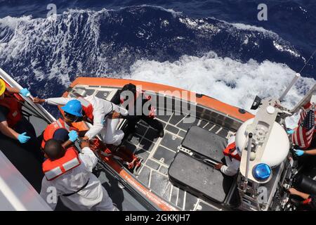 L'équipage de la Garde côtière Cutter Donald Horsley rapatrie 66 migrants dans un bateau de patrouille de la marine de la République dominicaine juste au large de Punta Cana, République dominicaine le 18 mai 2021, suite à l'interdiction de deux voyages illégaux dans les eaux du passage de Mona au large de Porto Rico. Les interdépendances sont le résultat des efforts en cours déployés par les organismes partenaires du Groupe interagences frontalières des Caraïbes (GCEI) dans leur objectif commun de sécuriser les frontières de Porto Rico contre les migrants illégaux et le trafic de drogues. Banque D'Images