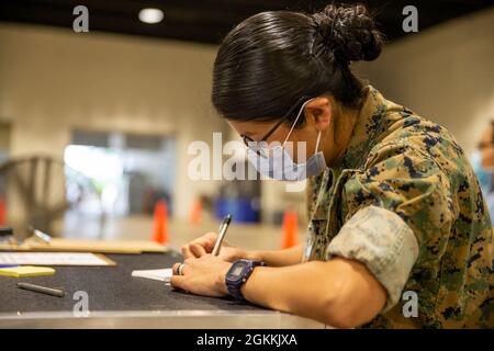 L'Hospitalman de la Marine américaine Karina Lopez Damian, affecté à la division marine 2d, Camp Lejeune, Caroline du Nord, prépare des cartes de vaccination au Centre de vaccination communautaire du Pipkin Building, au Liberty Bowl Memorial Stadium, à Memphis, Tennessee, le 18 mai 2021. Le Commandement du Nord des États-Unis, par l'intermédiaire de l'Armée du Nord des États-Unis, demeure déterminé à fournir un soutien souple et continu du ministère de la Défense à l'Agence fédérale de gestion des urgences dans le cadre de la réponse pangouvernementale à la COVID-19. Banque D'Images