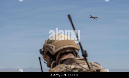 Un commandant aérien tactique de guerre spécial Airman, du 124e Escadron des opérations de soutien aérien, observe une démonstration de force d'un Thunderbolt II A-10 de la 124e Escadre Fighter au Centre d'entraînement au combat Orchard, au sud de Boise, Idaho, le 18 mai 2021. Les A-10 viennent de terminer la première chute en direct de l’OCTC dans l’histoire de l’aile. Banque D'Images