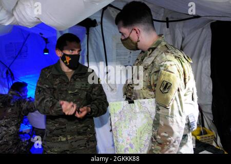 Le Lt. Carlos Bayonn Roman, officier de liaison espagnol au 1er Bataillon, 6e Régiment d’artillerie de campagne, s’entretient avec le Capt John Kenny, officier de direction des incendies pour 1-6 FAR, pour coordonner une mission d’incendie entre les deux pays le 18 mai 2021 dans la zone d’entraînement de Grafenwoehr, L'Allemagne dans le cadre de l'exercice multinational d'artillerie de tir direct Dynamic Front 21. Le DF21 est un exercice dirigé par le 7e Commandement de l’instruction de l’Armée de terre, dirigé par l’Armée des États-Unis en Europe et en Afrique, conçu pour accroître la préparation, la létalité et l’interopérabilité en exerçant la capacité des nations alliées et partenaires d’intégrer les feux communs i Banque D'Images