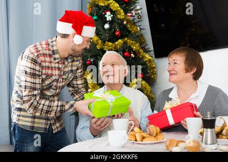 Parents et fils échangeant des cadeaux de Noël Banque D'Images