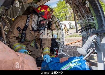 Les pompiers, affectés à la 180e Escadre de chasseurs de la Garde nationale de l’Ohio, évaluent le statut d’une victime lors d’une simulation d’accident d’avion à l’aéroport Eugene F. Kranz Toledo Express de Swanton (Ohio), le 18 mai 2021. L'exercice a permis aux premiers intervenants civils et militaires locaux de travailler ensemble pour obtenir une expérience pratique de qualité dans un environnement commun, afin de s'assurer qu'ils sont prêts en cas de mauvaise gestion de l'avion. Banque D'Images