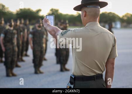 Sergent d'état-major Daniel L. Avila Jr., instructeur de forage principal de la Compagnie Alpha, 1er Bataillon d'entraînement des recrues, observe sa carte de forage lors de l'exercice final à bord du corps de Marine Recruit Depot Pariris Island, S.C., 19 mai 2021. Les tests finaux forent les instructeurs sur leur capacité à donner des commandes de forage et les recrues sur leur capacité à exécuter les mouvements correctement. Banque D'Images