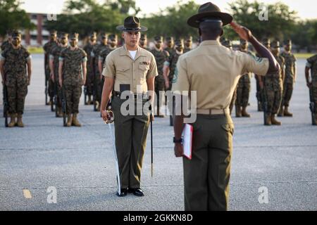 Sergent d'état-major Daniel L. Avila Jr., instructeur principal de forage à la Compagnie Alpha, 1er Bataillon d'entraînement des recrues, présente le rapport lors de l'exercice final à bord du corps de Marine Recruit Depot Pariris Island, S.C., 19 mai 2021. Les tests finaux forent les instructeurs sur leur capacité à donner des commandes de forage et les recrues sur leur capacité à exécuter les mouvements correctement. Banque D'Images