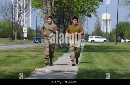 L’ancien Airman Marcel Ramirez, à gauche, au 319e Escadron des forces de sécurité, sécurité physique, et Tech. Sgt. Jason Naputi, 319e officier non commandant de la sécurité de l’Agence de reconnaissance, se rend sur le trottoir tout en participant au défi des défenseurs à la base aérienne de Grand Forks, N.D., le 19 mai 2021. Le défi des défenseurs a eu lieu en l'honneur de la semaine de la police qui s'est déroulée du 9 au 15 mai 2021. Banque D'Images