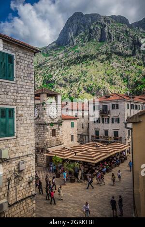 Place de la ville à Kotor Montenegro avec la Torre del reloj et les gens assis dans un café extérieur. Banque D'Images