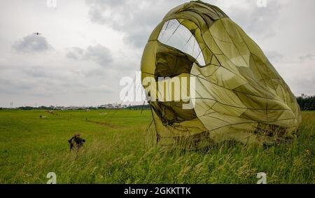 Un soldat de la Force terrestre d'autodéfense du Japon affecté aux terres de la 1re Brigade aéroportée sur la zone d'entraînement Narashino du JGSDF, Japon, le 20 mai 2021, lors d'un saut bilatéral en vol. Cent quarante-trois parachutistes de la JASDF ont effectué des sauts aériens à partir du C-130J Super Hercules de la U.S. Air Force affecté au 36e Escadron de transport aérien afin d'améliorer les compétences tactiques nécessaires aux opérations aériennes. Banque D'Images